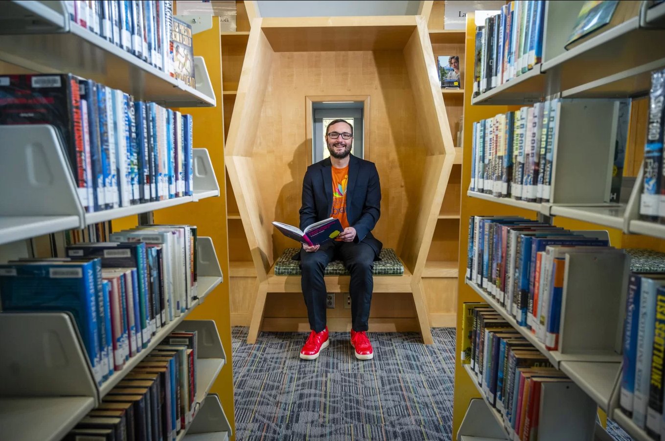 Noah Lenstra reading in a library