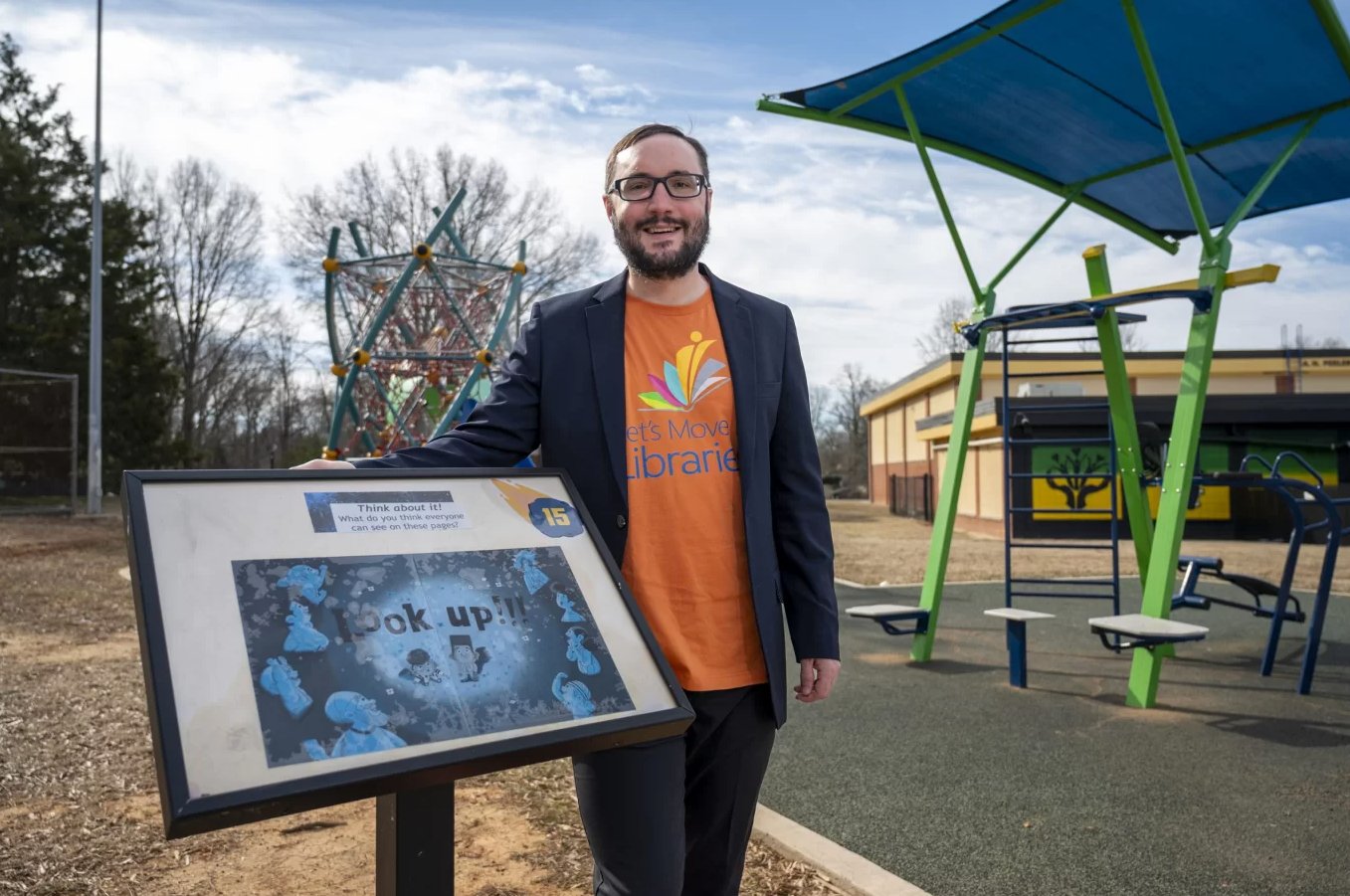 Noah Lenstra with StoryWalk display at a library